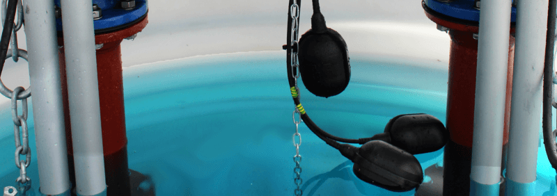 Black non-mercury float switches in a tank.