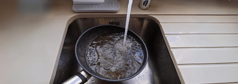 Cooking oil being washed down a sink